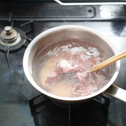 鍋に湯を沸かし、沸騰直前になったら牛薄切り肉を数枚ずつ入れて湯の中で泳がせる。
肉の色が変わったらザルに上げる。全ての肉を茹で、ザルに上げる。