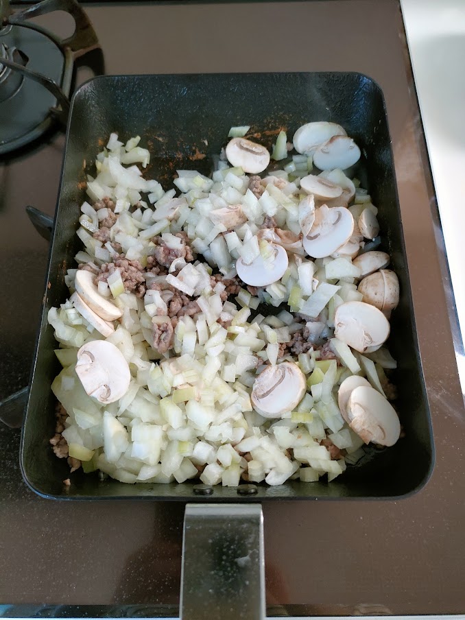 汚れをふき取り、油（分量外）をひいて、挽肉の色が変わるまで炒めてから、玉ねぎ・マッシュルームを入れて炒める。