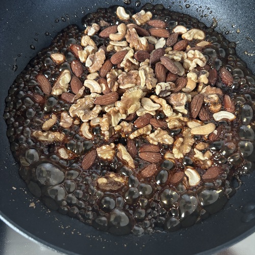 菜箸で混ぜながら加熱し、黒糖が溶けたらナッツを入れる。