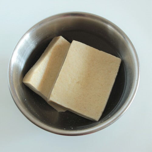 戻した高野豆腐は手で優しく挟んで水を絞り、半分の薄さに切る。
