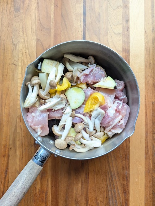鍋に鶏肉・野菜を入れ、塩（小さじ1/4）とオリーブオイルをからめる。
