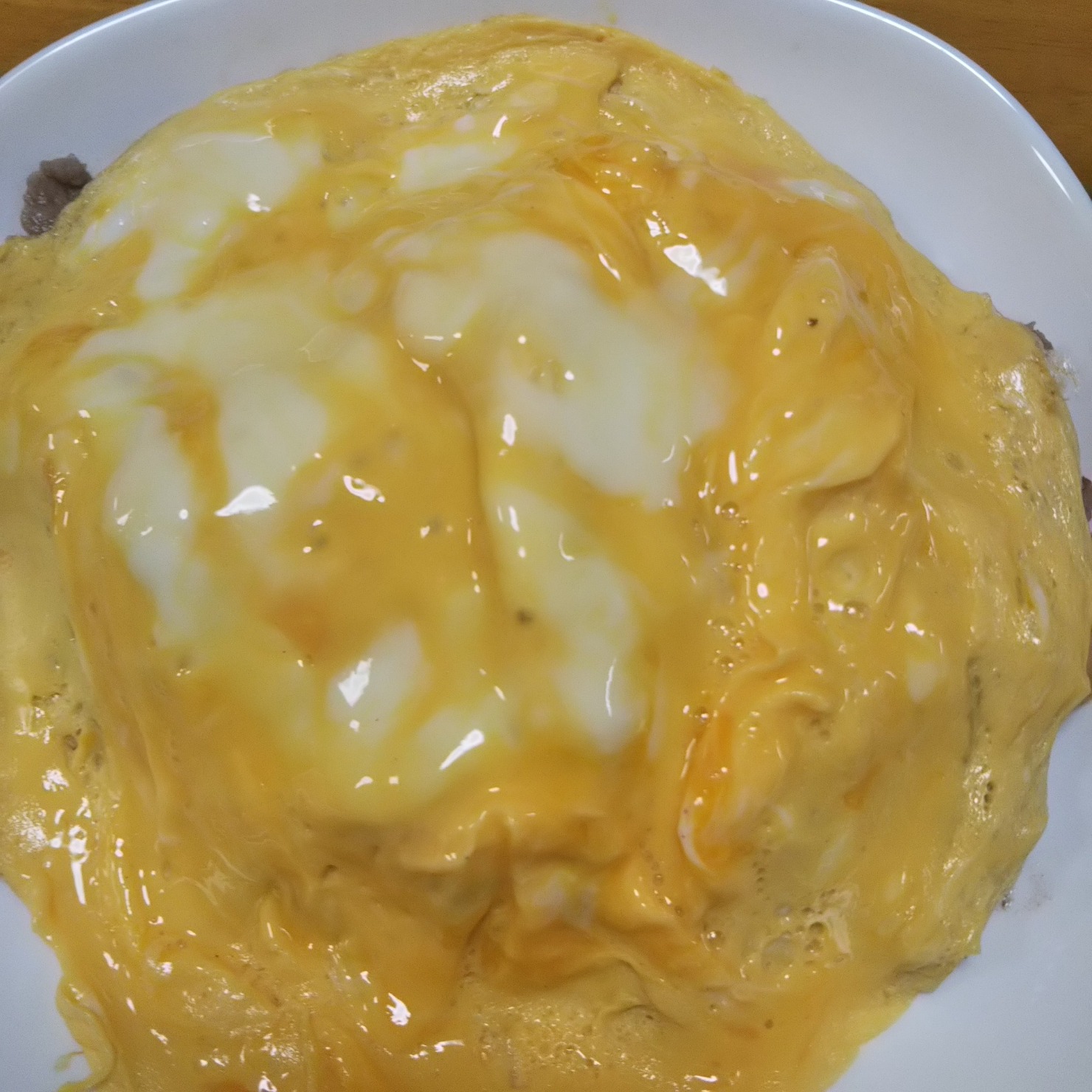 卵を薄く焼いて、炒めた牛肉と野菜をの上にのせる。ケチャップをかけて完成。
