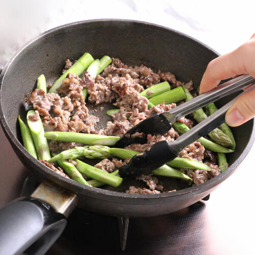 牛肉に火が通ったらアスパラガスも入れて炒め、アスパラガスに火が通ったらオイスターソースを加えて全体を混ぜ、皿に盛る。