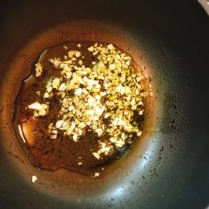 熱したフライパン(深型)に、オリーブ油とみじん切りのニンニクを焦がさないようにゆっくり香りを出しながら炒めていく。