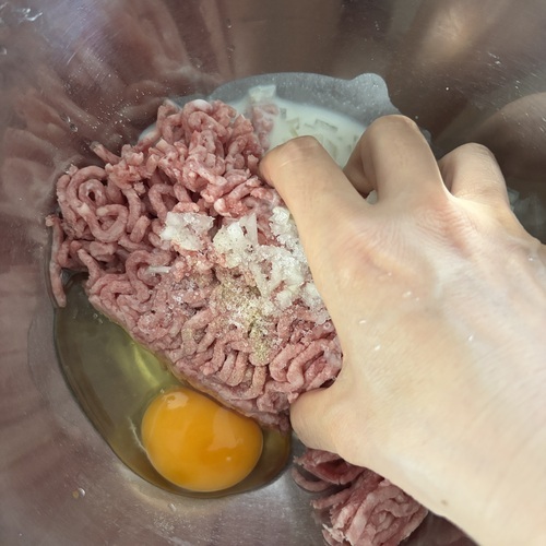 ボウルに合い挽肉・玉ねぎ・卵・下準備したパン粉・塩・こしょうを入れて、粘りが出るまでよく混ぜる。
