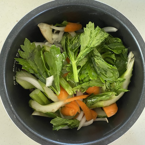 圧力鍋に豚塊ロース肉を置き、その上に野菜をのせる。水カップ1と顆粒コンソメを加えたら50分加圧し、冷めるまで置いておく。