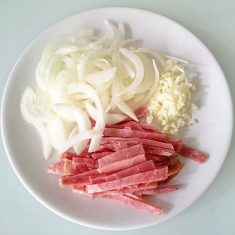ベーコンと玉ねぎを千切りにし、にんにくをみじん切りにする。