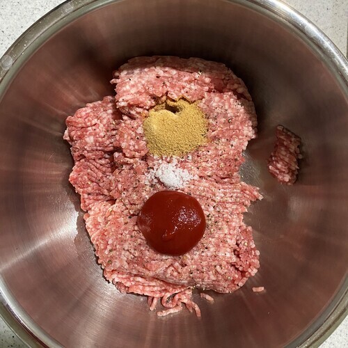 ボウルに合い挽き肉と塩こしょう、ケチャップ、コンソメを入れてよく捏ねる。
