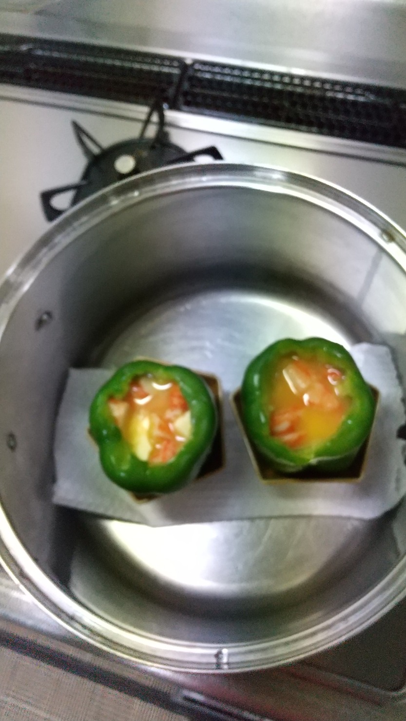 鍋に破れないキッチンペーパーを敷きます 鍋に器に立てたパプリカを入れてお湯を注ぎます