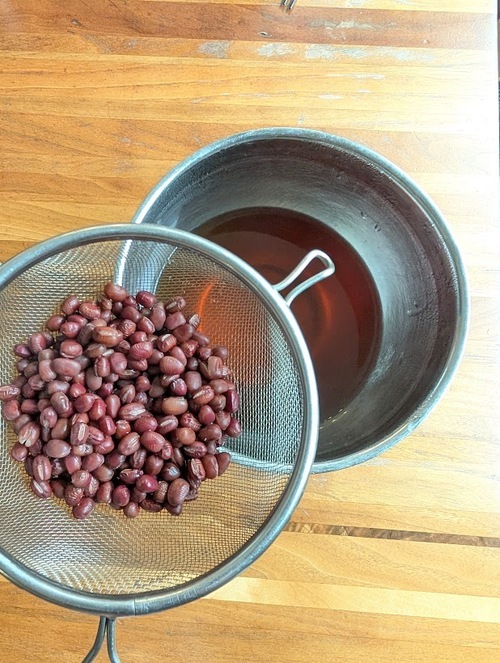 煮汁は捨てずに、豆はザルにあげて冷ましておく。