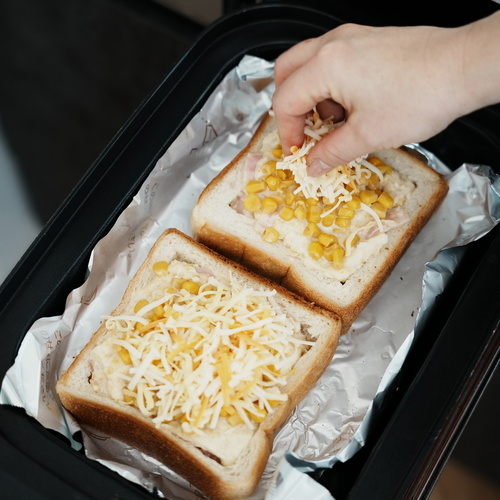 コーンとピザ用チーズをかけて波型プレートに乗せ、マルチグリルのオートメニュー［トースト］の弱で加熱する。