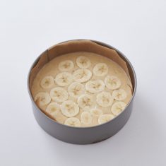 クッキングシートを敷いたケーキ型に③をいれ、輪切りのバナナをのせる。