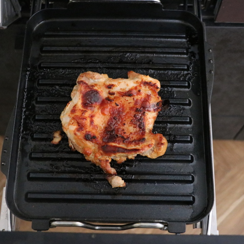鶏もも肉を取り出し、ヨーグルトみそを軽くふき取り、皮目を上にしてマルチグリルの波型プレートの上に置き、調理モード [焼く]の中火で13～15分加熱する。
残り2分程度のところで緑、赤ピーマンを一緒に焼いて皿に盛る。