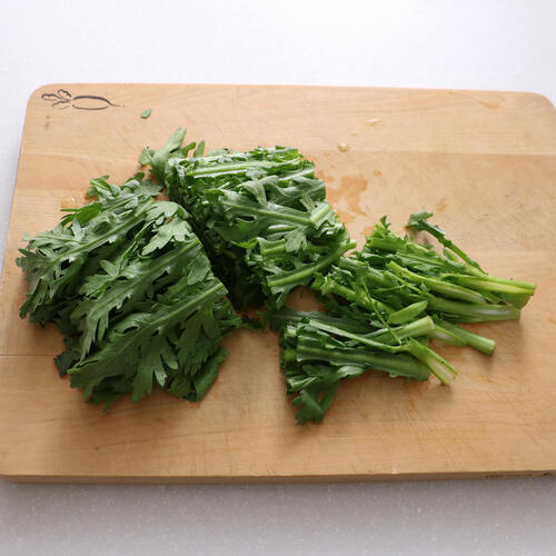 春菊は3等分の長さに切り分け、茎の部分は細く切る。
