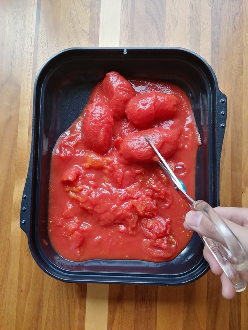 トマト缶はキッチンバサミで適当な大きさにカットする。