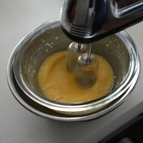 卵をボウルに割り入れ、湯せんにかける。砂糖を3回に分けて加えながら、白く泡立つまでハンドミキサーで泡立てる。