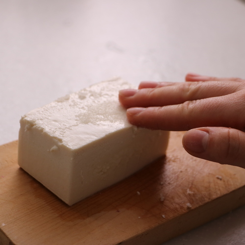 絹ごし豆腐に塩をまぶし、キッチンペーパーで巻いたら冷蔵庫で一晩おく。
