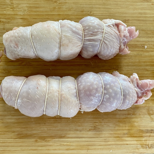 鶏もも肉に塩胡椒を振りかけ、皮目が外側になるように横長に巻いてタコ糸で縛る。生姜は薄切り、にんにくは包丁で潰す。