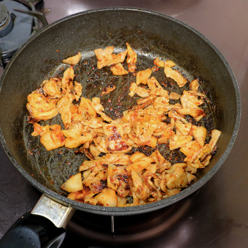 フライパンにごま油を加えて中火で熱し、豚バラ肉を加えて炒める。
豚バラ肉から油が出てきたらキムチも加え、こんがり焼き色がつくくらいまでしっかり炒める。