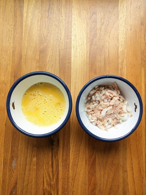 卵を割り入れ、塩少々を加えて、よく混ぜる。ツナ缶の油を程よくきり、みじんぎりにした玉ねぎを混ぜる。