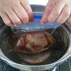 鍋に張った水の中で、ジップロックの空気を抜く。