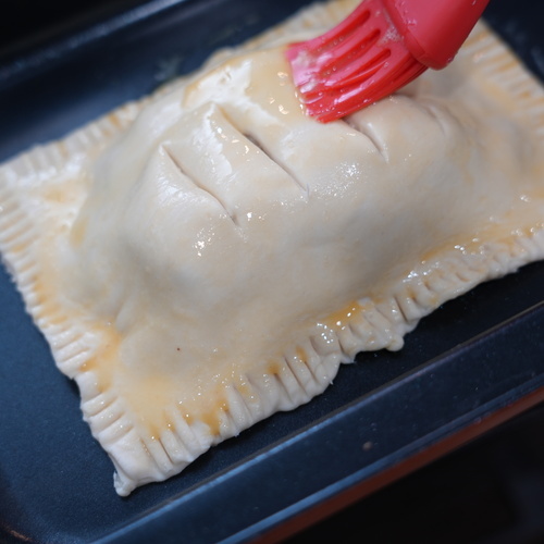 もう一枚のパイ生地を麺棒で少し伸ばし、④に乗せる。
3か所に切り込みを入れ、フチをフォークで押さえる。
卵に塩を加えてよく溶き、パイ生地の表面に塗る。
