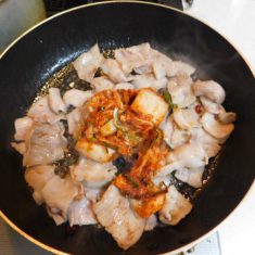 フライパン油、にんにく、とうがらしをいれ、火にかけ、かおりが出てきたら、豚バラ肉をいれ、炒める。