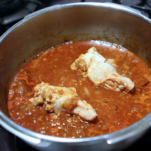 1の鍋にトマトジュース、水、顆粒コンソメ、鶏手羽元肉を加えてフタをして中火で10分煮る。
