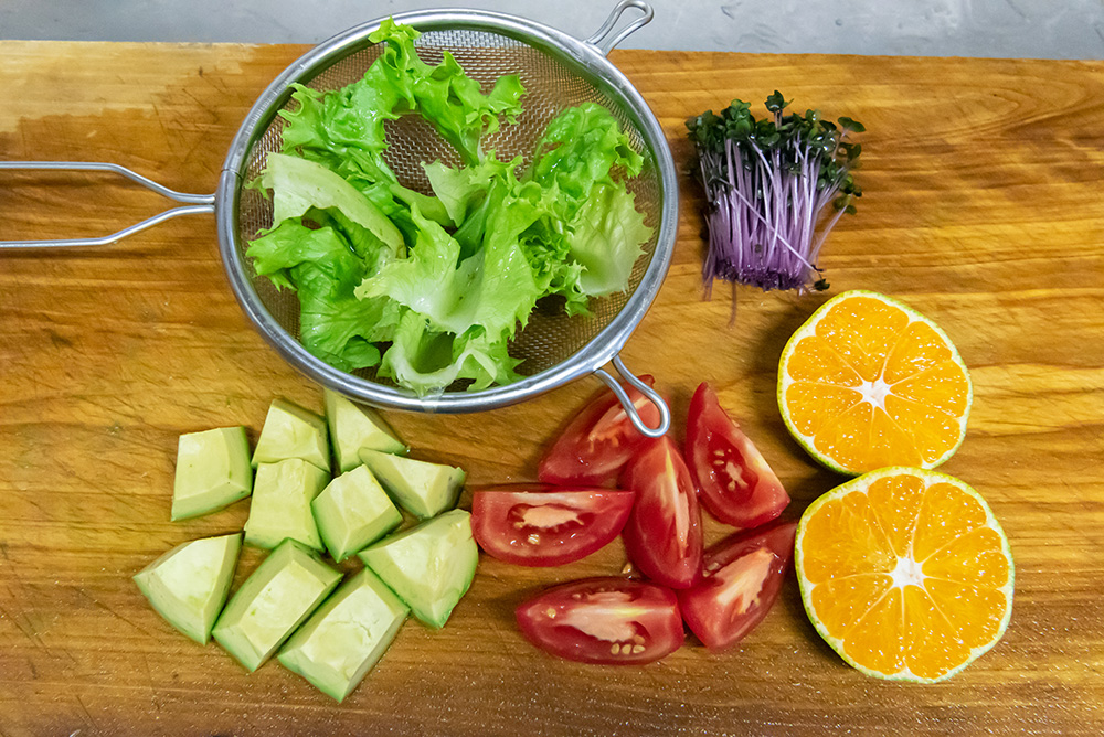みかんは半分に切って絞る。サラダに使う野菜も食べやすく切る。