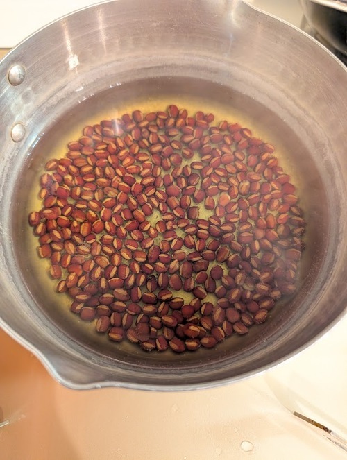 再びあずきを鍋に戻し、500mlの水を入れ、上面「湯沸かし・30分」でやや固めに茹でる。（ぐつぐつ茹でると皮が割れてしまうので注意）