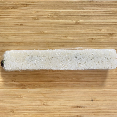 ラップの箱の蓋を開け、内側にラップを広げる。酢飯1/2を敷き詰め、具材を重ねる。残りの酢飯を上から被せラップで包むようにして蓋をする。ラップの蓋を閉め軽く押してから取り出す。